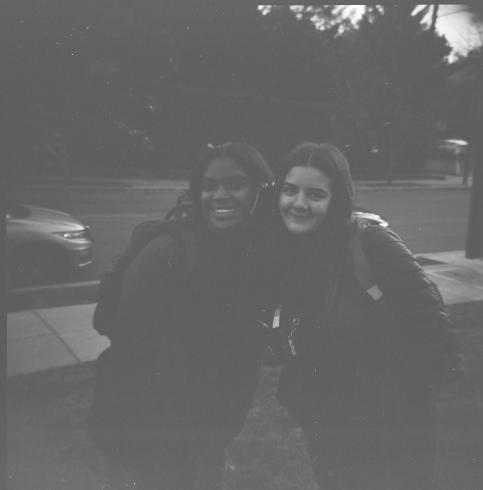 Black and white portrait of two people smiling at the camera 