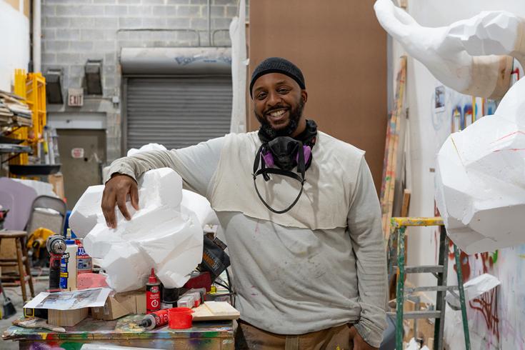 Wesley Clark in his studio smiling with his artwork