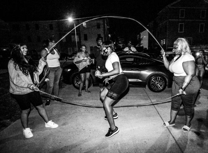 Black and white photograph of women playing double dutch on the street