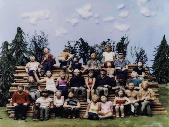 Photograph of a group of people made of clay at a camp
