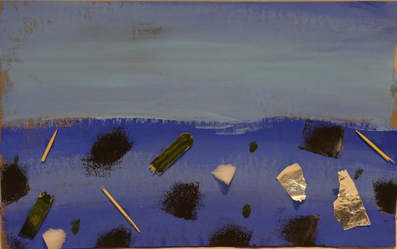 An ocean scene with black painted spots, toothpicks, and broken popsicle sticks.
