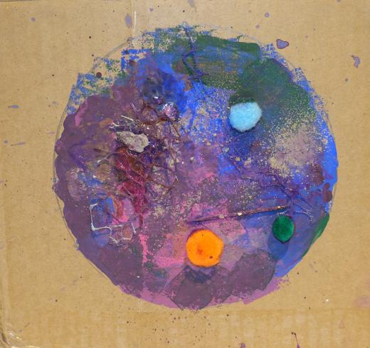 A colorful circle with pom-poms and ash.