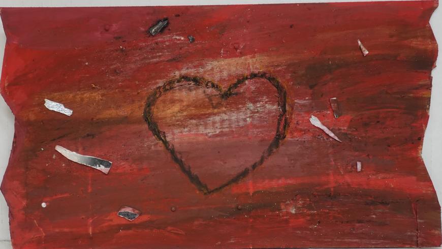A red heart outlined in black with shards of mirror surrounding it.