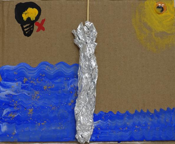 Piece of tin foil wrapped around a stick in an ocean scene.