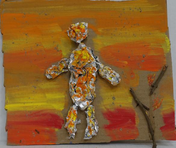 Tin foil figure covered with yellow and orange paint.