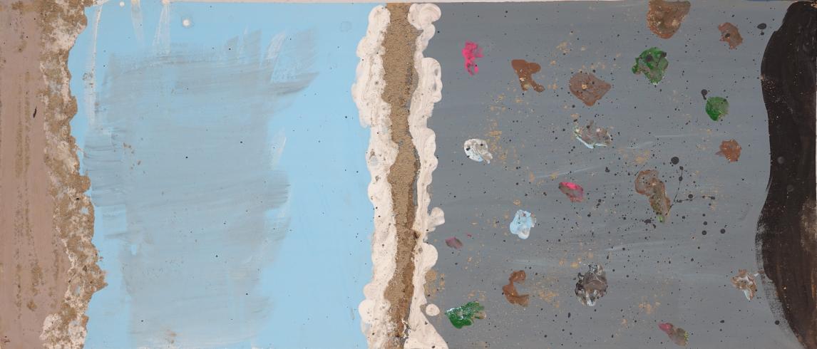 A beach with gray water and splattered paint.
