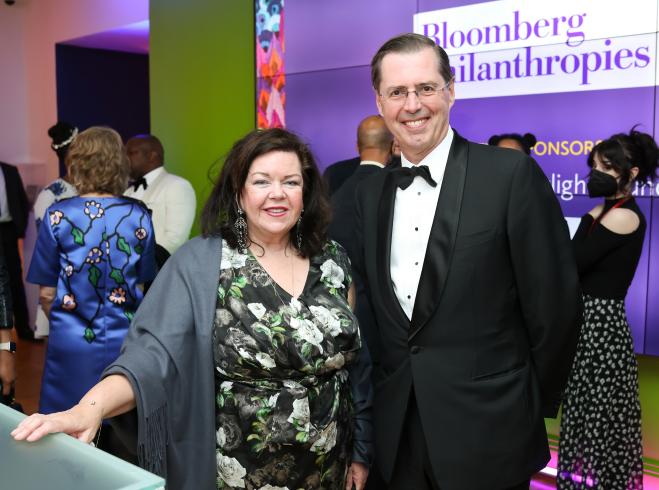 Photograph of two people in black tie standing together smiling at the camera