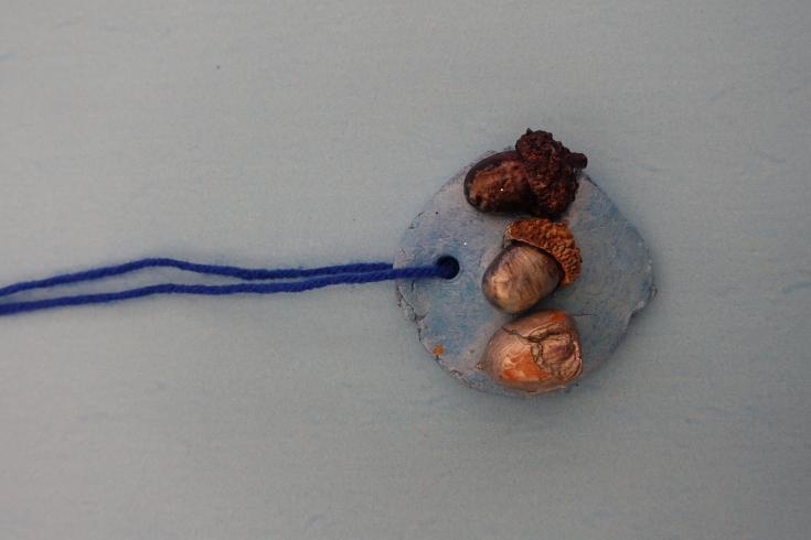 Clay mobile with three painted acorns.