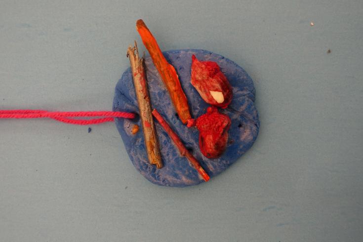 Blue clay mobile with painted sticks and acorns.