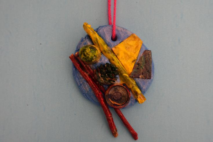 Clay mobile with painted nature pieces.
