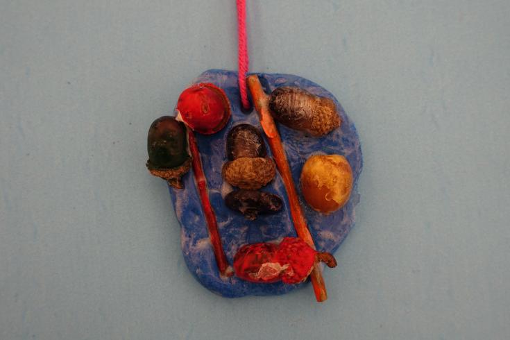 Clay mobile with painted acorns.