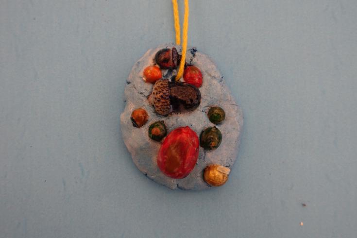 Clay mobile with painted acorns.