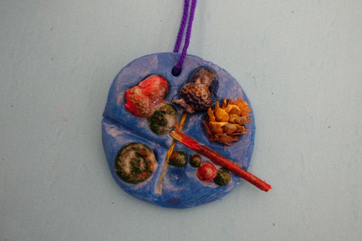 Clay mobile with painted nature pieces.