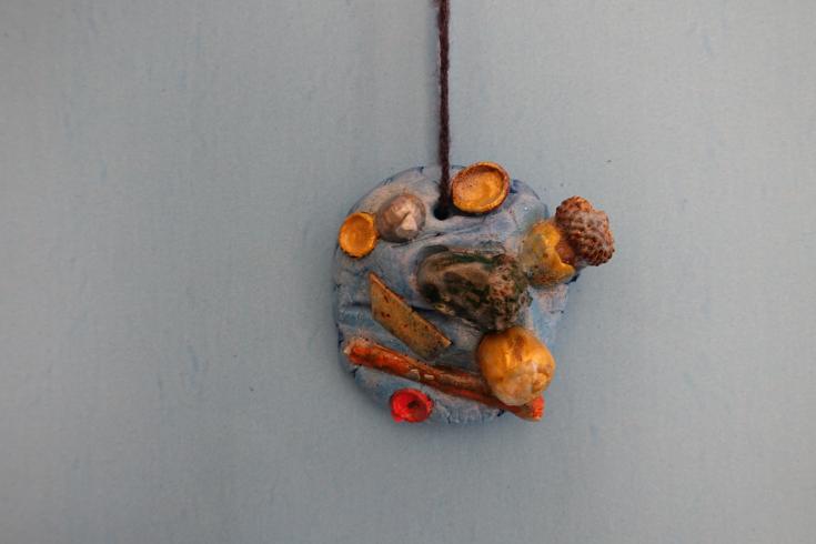 Clay mobile with painted acorns.