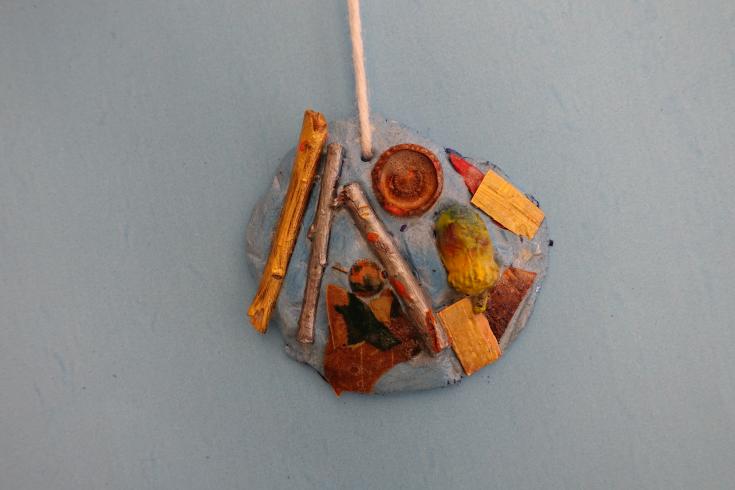 Clay mobile with painted sticks and acorns.