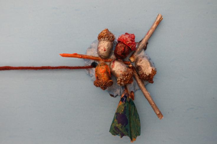 Clay mobile with painted acorns and sticks.