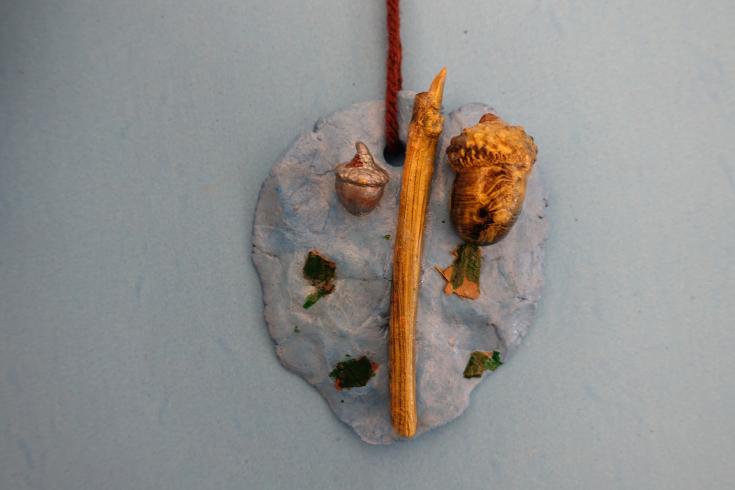 Clay mobile with painted sticks and acorns.