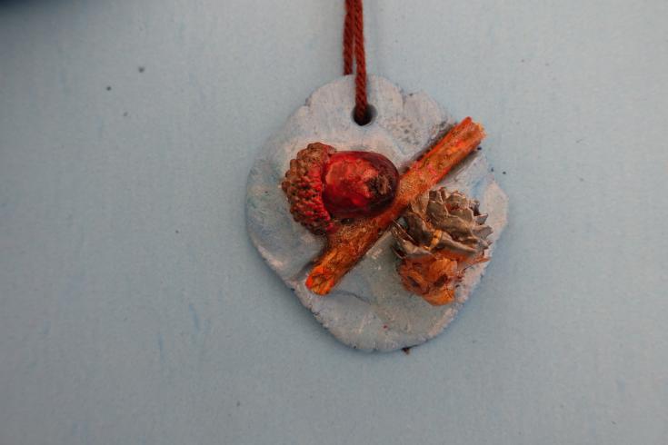 Clay mobile with a painted acorn and pinecone.