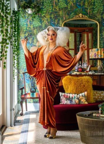 Photograph of Anja standing arms raised in fancy room