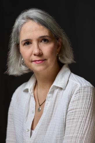 Headshot of Holly Twyford wearing white shirt with black background