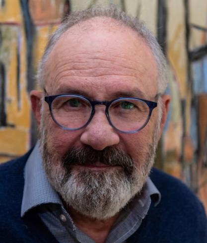 Headshot of Rick Foucheux wearing glasses and blue collared shirt and sweater