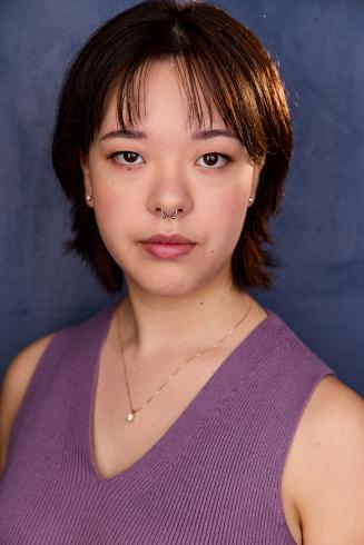 Headshot of Sedona Salb not smiling with blue background