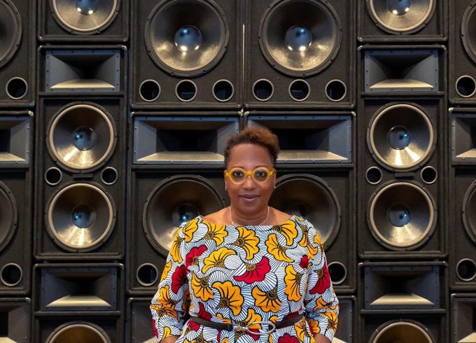 Valerie Cassel Oliver standing in front of black speakers