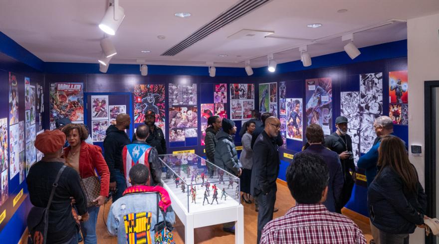 People mingling in a gallery with walls covered in comic illustrations