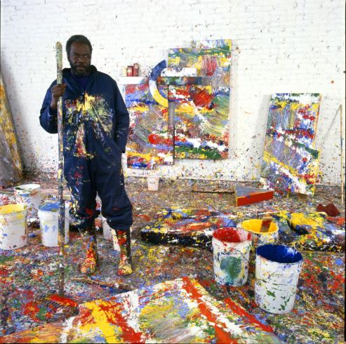 A person standing in a paint splattered studio