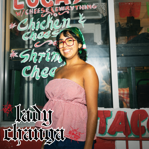 Lady Changa standing in front of storefront windows