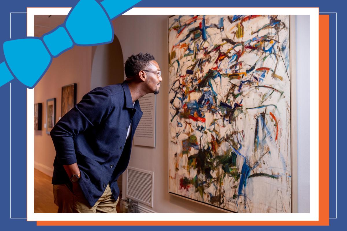Photograph of a man looking at a painting, with a bow graphic in the corner