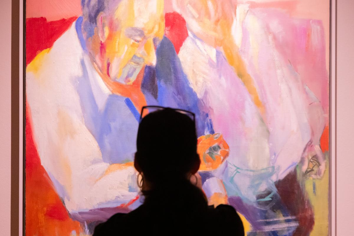 Woman standing in front of one of Vivian Brown's Little Men paintings